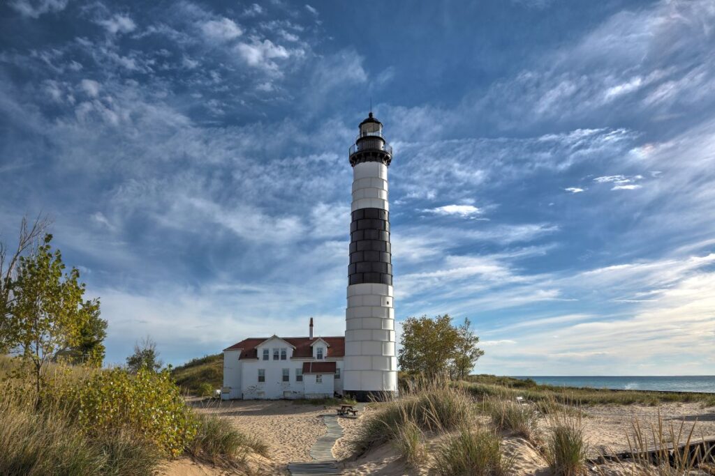 Big Sable Point Lighthouse black-and-white striped tower rises above the dunes at Ludington State Park on Lake Michigan.