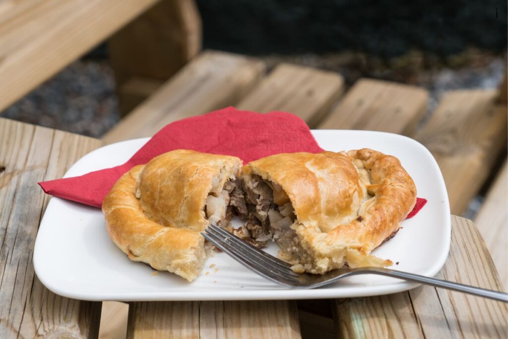 A traditional Cornish pasty cut open to show the beef, potato, and rutabaga filling — the defining food of Michigan's Upper Peninsula