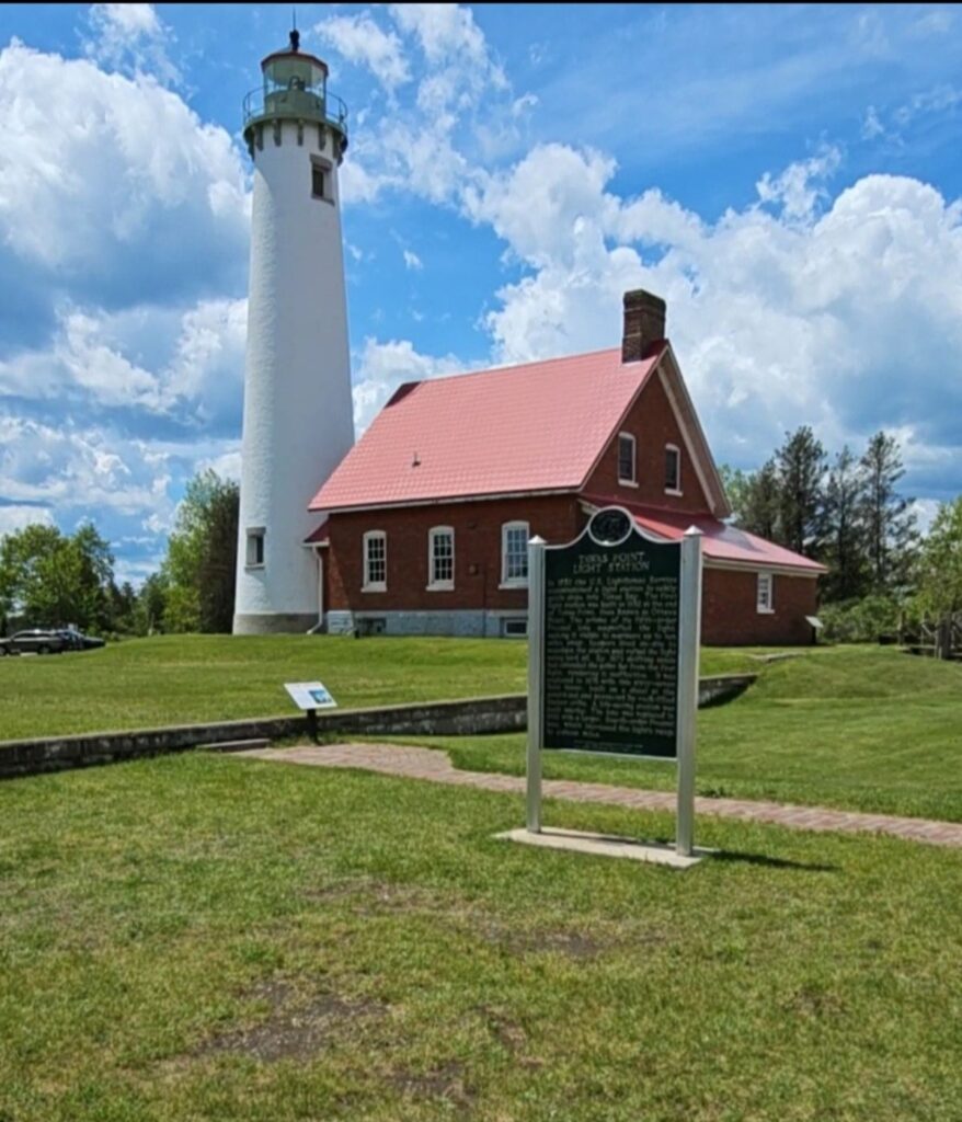 Little Sable Point Lighthouse rises above dune grass and pines at Silver Lake State Park on Lake Michigan.