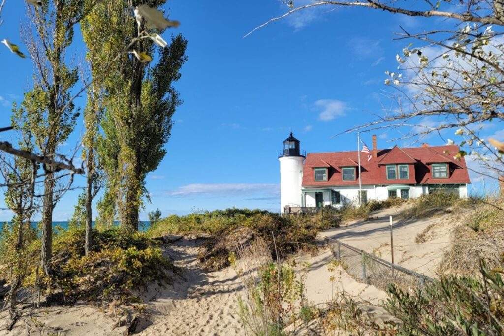 Point Betsie Lighthouse white tower and red-roofed keeper's house above the Lake Michigan dunes near Frankfort, Michigan.