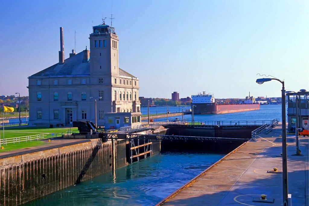 The Soo Locks in Sault Ste. Marie, Michigan, with the Administration Building and a Great Lakes freighter passing on the St. Marys River