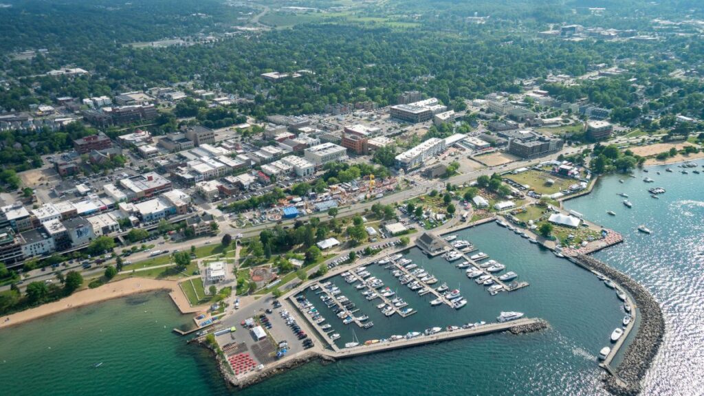 Aerial view of downtown Traverse City Michigan with marina, beach, and Cherry Festival setup along Grand Traverse Bay.